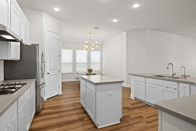124 Adina Dr, Dripping Springs, TX 78620 - kitchen featuring a sink, dark wood-style floors, stainless steel gas stovetop, a kitchen island, and a chandelier