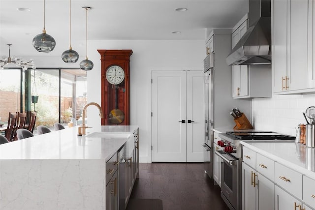 4420 Mount Vernon Dr Unit A, Austin, TX 78745 - kitchen featuring high end stainless steel range, wall chimney exhaust hood, dark wood finished floors, tasteful backsplash, and a kitchen island with sink