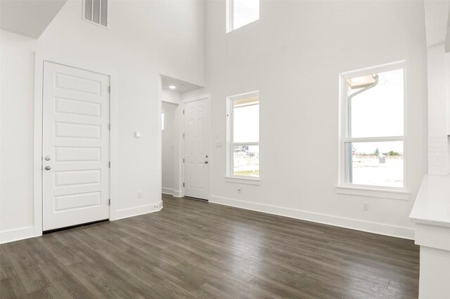 2035 Cora Ivy Loop, Round Rock, TX 78665 - unfurnished living room featuring dark wood-style floors, baseboards, and a high ceiling