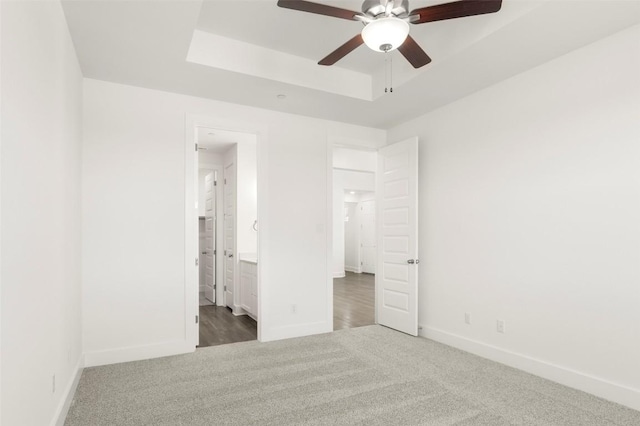2035 Cora Ivy Loop, Round Rock, TX 78665 - unfurnished bedroom featuring carpet, baseboards, a tray ceiling, ensuite bath, and ceiling fan