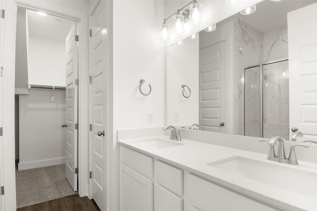 2035 Cora Ivy Loop, Round Rock, TX 78665 - full bathroom with a marble finish shower, wood finished floors, baseboards, and double vanity