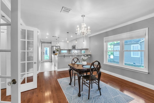 1308 Kinney Ave, Austin, TX 78704 - dining area with ornamental molding, a chandelier, baseboards, wood finished floors, and recessed lighting