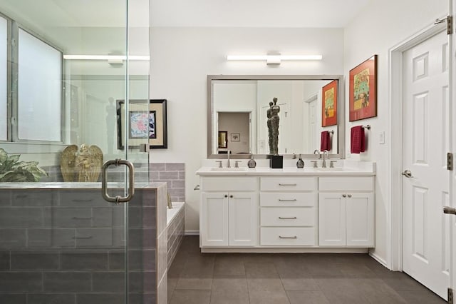 bathroom with tile patterned flooring, a stall shower, a garden tub, and double vanity
