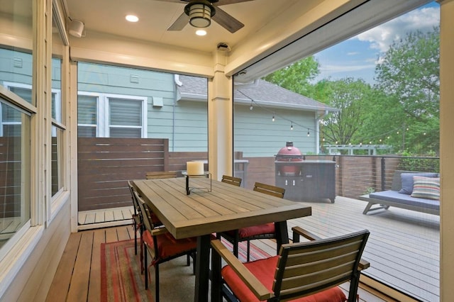 wooden terrace with a ceiling fan, outdoor dining space, and a baseboard radiator