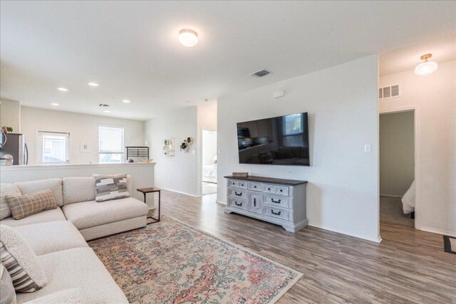 living area featuring wood finished floors, baseboards, and recessed lighting