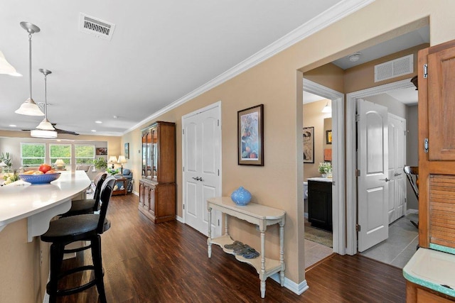 308 Hobby St, Georgetown, TX 78633 - kitchen featuring dark wood-type flooring, light countertops, a kitchen breakfast bar, hanging light fixtures, and baseboards