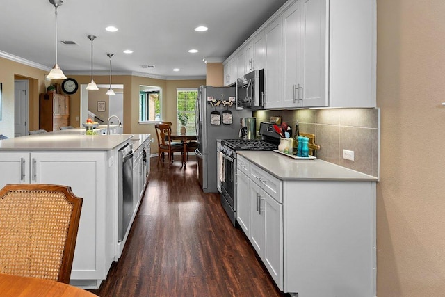 308 Hobby St, Georgetown, TX 78633 - kitchen with stainless steel appliances, dark wood finished floors, crown molding, white cabinetry, and tasteful backsplash