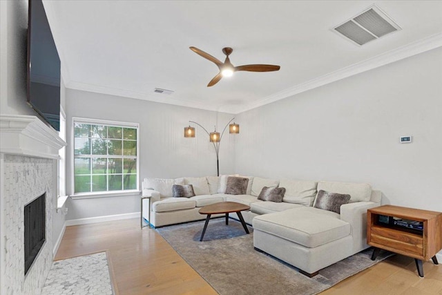 6301 Harrogate Dr, Austin, TX 78759 - living area featuring wood finished floors, a ceiling fan, a fireplace with flush hearth, and crown molding