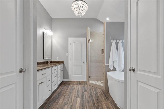 6301 Harrogate Dr, Austin, TX 78759 - bathroom featuring a freestanding bath, double vanity, a shower stall, wood finished floors, and a chandelier