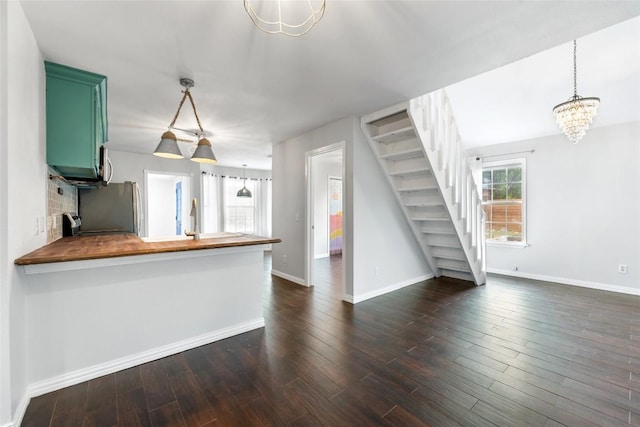 11708 Hornsby Dr, Austin, TX 78753 - kitchen with wood counters, fridge, a chandelier, a peninsula, and baseboards