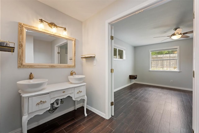 11708 Hornsby Dr, Austin, TX 78753 - bathroom with wood finished floors, double vanity, baseboards, and ceiling fan