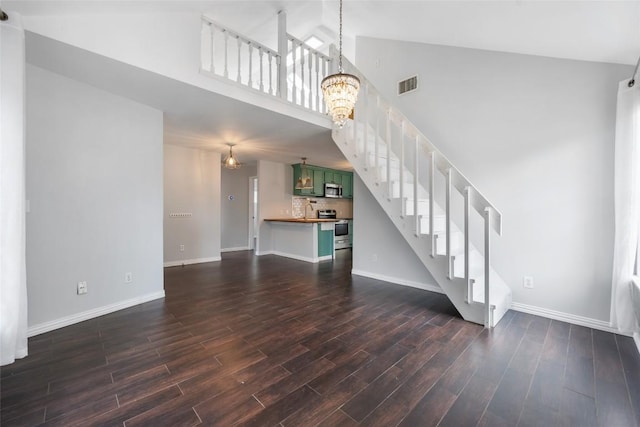 11708 Hornsby Dr, Austin, TX 78753 - unfurnished living room with baseboards, a towering ceiling, stairs, and dark wood-style floors