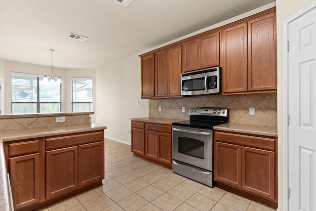 5405 English Oak Dr, Killeen, TX 76542 - kitchen featuring visible vents, a chandelier, brown cabinetry, stainless steel appliances, and backsplash