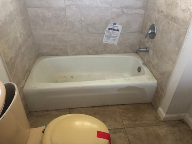 1008 W Pietzsch St, Bartlett, TX 76511 - bathroom featuring a tub to relax in, tile patterned floors, and baseboards