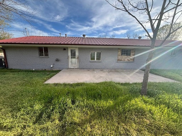 1008 W Pietzsch St, Bartlett, TX 76511 - back of house with metal roof, a patio area, brick siding, and a yard