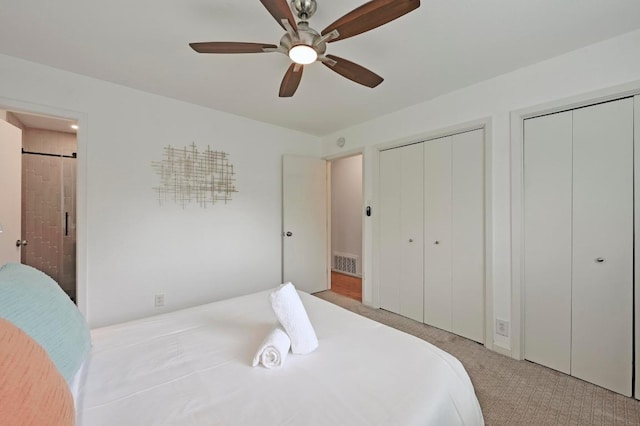 2301 Trafalgar Dr, Austin, TX 78723 - carpeted bedroom featuring two closets, connected bathroom, and ceiling fan