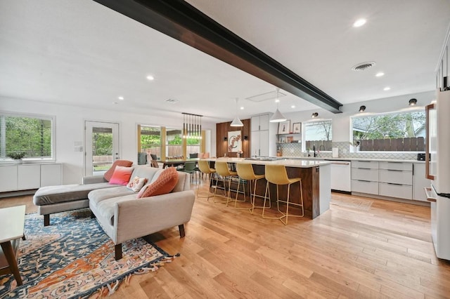 2301 Trafalgar Dr, Austin, TX 78723 - living area featuring healthy amount of natural light, beam ceiling, light wood finished floors, and recessed lighting