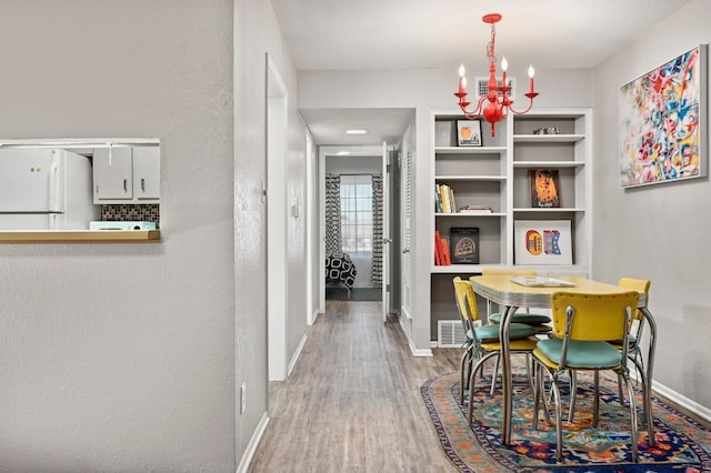 2425 Ashdale Dr Unit 78, Austin, TX 78757 - dining room featuring wood finished floors, an inviting chandelier, baseboards, and visible vents