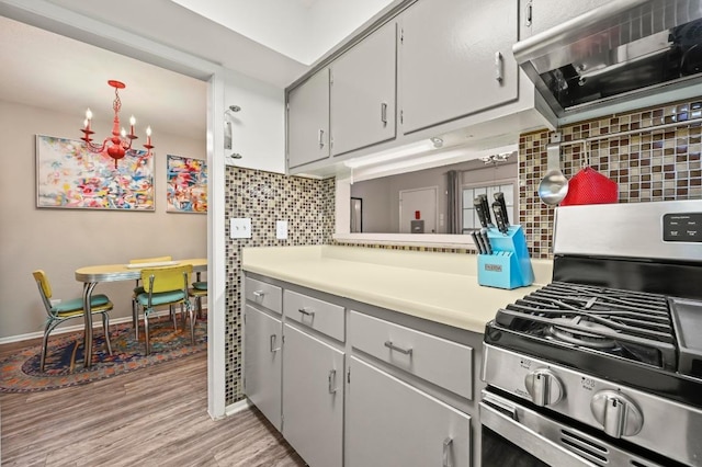 2425 Ashdale Dr Unit 78, Austin, TX 78757 - kitchen with tasteful backsplash, ventilation hood, light countertops, light wood finished floors, and gas stove