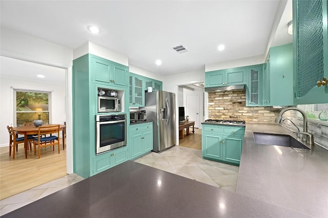 5708 Bullard Dr, Austin, TX 78757 - kitchen featuring appliances with stainless steel finishes, a sink, light tile patterned floors, tasteful backsplash, and visible vents