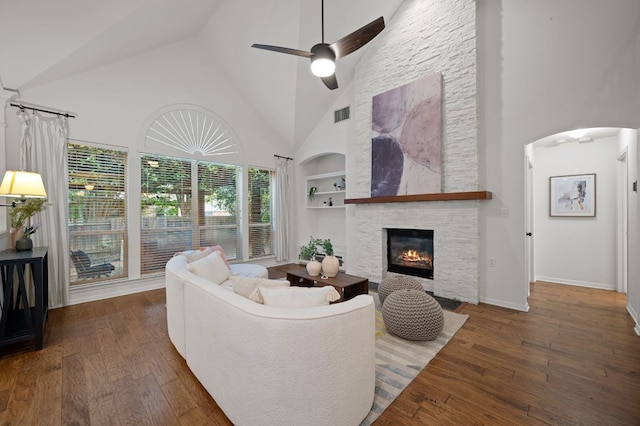 living area with high vaulted ceiling, a fireplace, visible vents, ceiling fan, and built in shelves