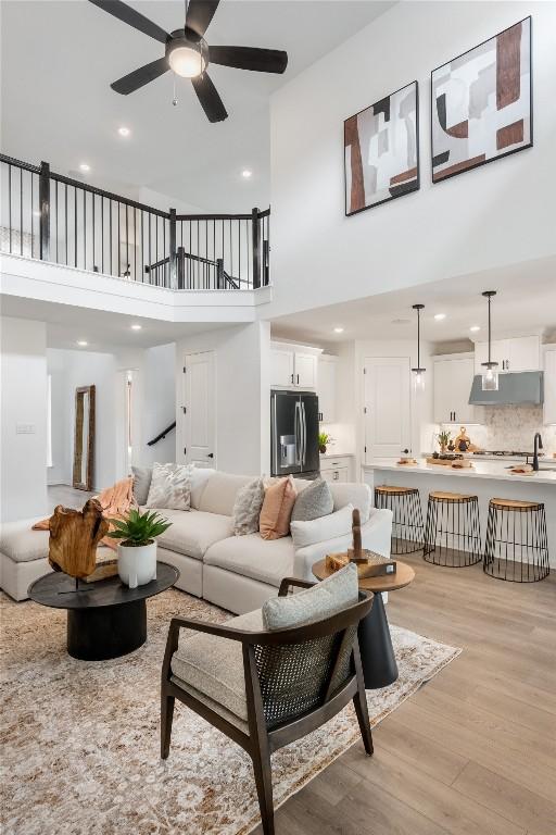 120 Amber Oak Ln, Georgetown, TX 78628 - living room featuring light wood-style floors, a towering ceiling, recessed lighting, and a ceiling fan
