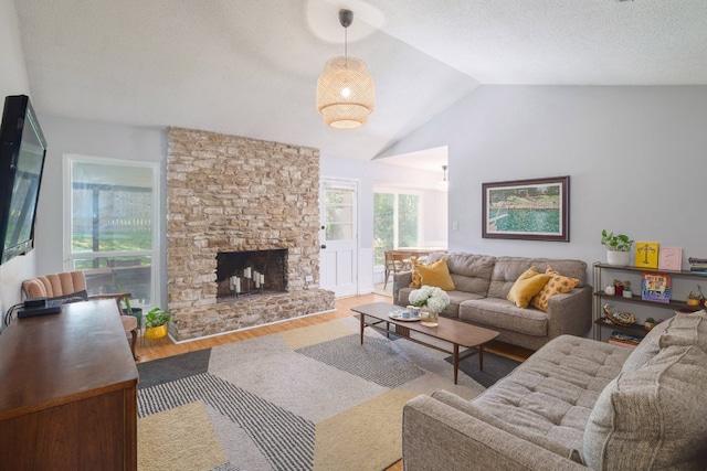 9605 Marston Ln, Austin, TX 78753 - living area featuring wood finished floors, vaulted ceiling, and a stone fireplace