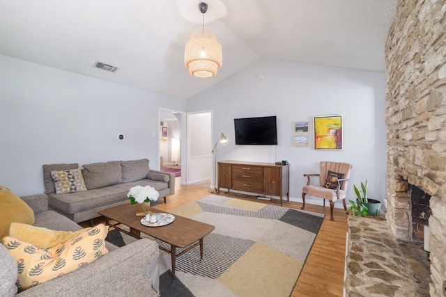 9605 Marston Ln, Austin, TX 78753 - living area with light wood-style flooring, vaulted ceiling, and a stone fireplace