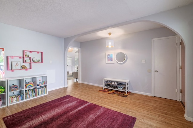 9605 Marston Ln, Austin, TX 78753 - game room with arched walkways, wood finished floors, baseboards, and a textured ceiling