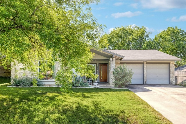 9605 Marston Ln, Austin, TX 78753 - view of front of house with a garage, driveway, a front lawn, and stone siding