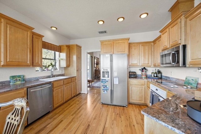 515 Coventry Rd, Spicewood, TX 78669 - kitchen with stainless steel appliances, light wood-type flooring, recessed lighting, dark stone countertops, and light brown cabinetry