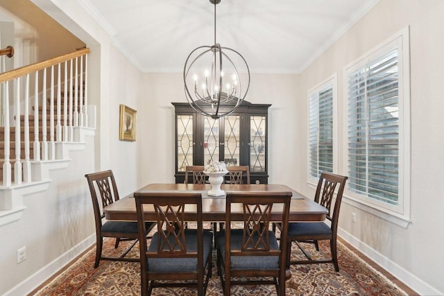 dining space with a chandelier, baseboards, wood finished floors, and crown molding