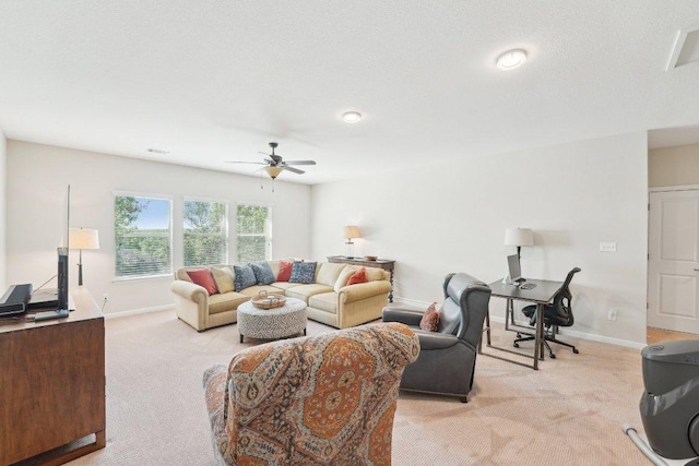 living area featuring baseboards, ceiling fan, and light colored carpet