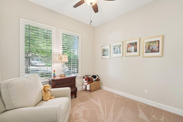 sitting room with ceiling fan, carpet, and baseboards