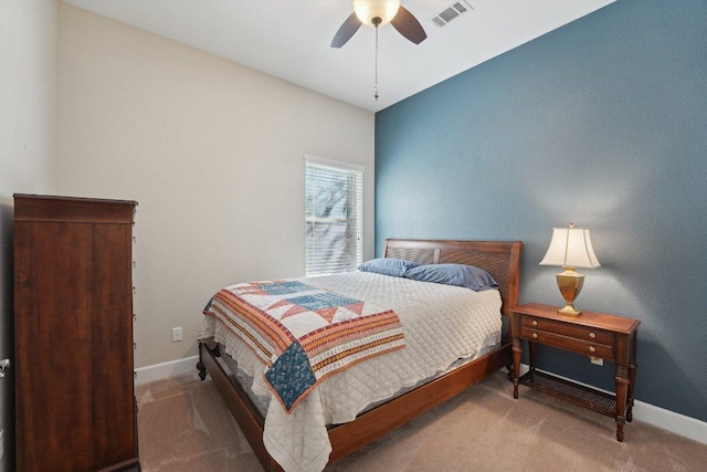 carpeted bedroom with baseboards, a ceiling fan, and visible vents