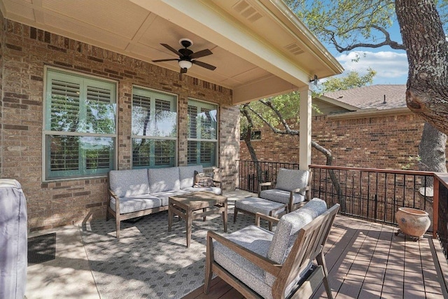wooden deck with outdoor lounge area and ceiling fan
