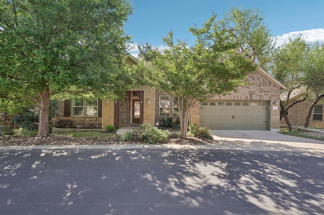 view of property hidden behind natural elements featuring a garage and driveway