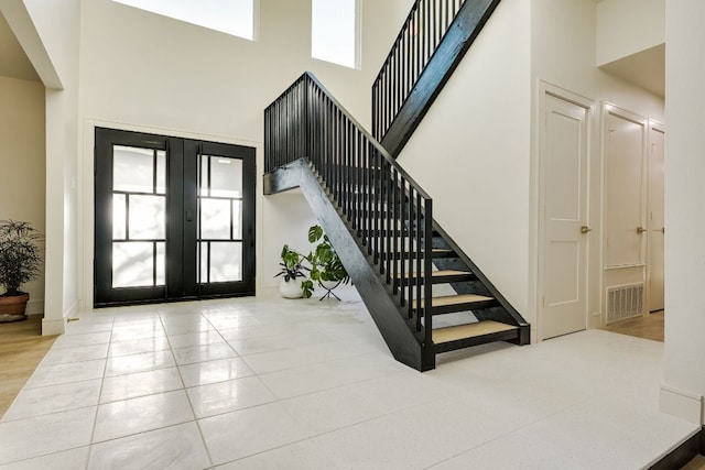 9909 Oliver Dr, Austin, TX 78736 - tiled entryway featuring stairway, a high ceiling, healthy amount of natural light, and french doors