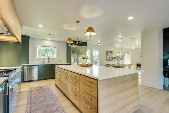 9909 Oliver Dr, Austin, TX 78736 - kitchen featuring high end appliances, light wood-type flooring, light countertops, backsplash, and a kitchen island