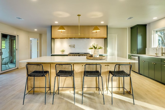 9909 Oliver Dr, Austin, TX 78736 - kitchen with a sink, stainless steel dishwasher, light wood-type flooring, recessed lighting, and light countertops