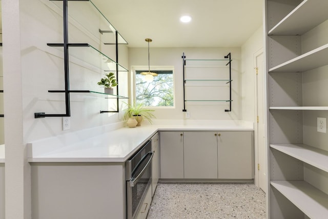 9909 Oliver Dr, Austin, TX 78736 - interior space with dark aggregate flooring, stainless steel oven, hanging light fixtures, and recessed lighting