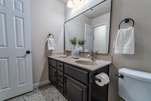 121 E Adelanta Pl, Round Rock, TX 78681 - bathroom featuring double vanity, toilet, and baseboards