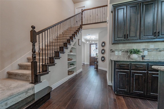 121 E Adelanta Pl, Round Rock, TX 78681 - stairs featuring baseboards, wood finished floors, a towering ceiling, and built in shelves