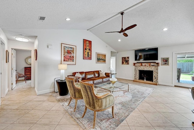6567 Fair Valley Trl, Austin, TX 78749 - living area with ceiling fan, light tile patterned floors, vaulted ceiling, a textured ceiling, and a fireplace