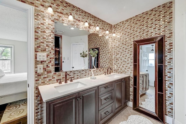 6567 Fair Valley Trl, Austin, TX 78749 - ensuite bathroom with double vanity, backsplash, and tile walls