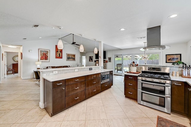 6567 Fair Valley Trl, Austin, TX 78749 - kitchen with stainless steel appliances, exhaust hood, light countertops, dark brown cabinets, and light tile patterned floors