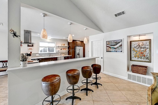 6567 Fair Valley Trl, Austin, TX 78749 - kitchen with island exhaust hood, appliances with stainless steel finishes, light countertops, a kitchen breakfast bar, and backsplash