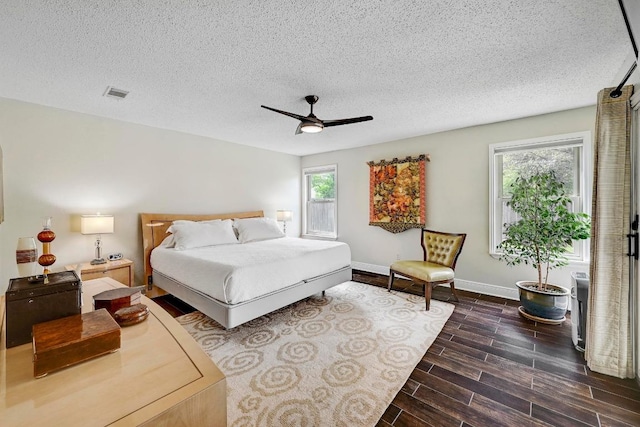 6567 Fair Valley Trl, Austin, TX 78749 - bedroom with a textured ceiling, a ceiling fan, and dark wood-style floors