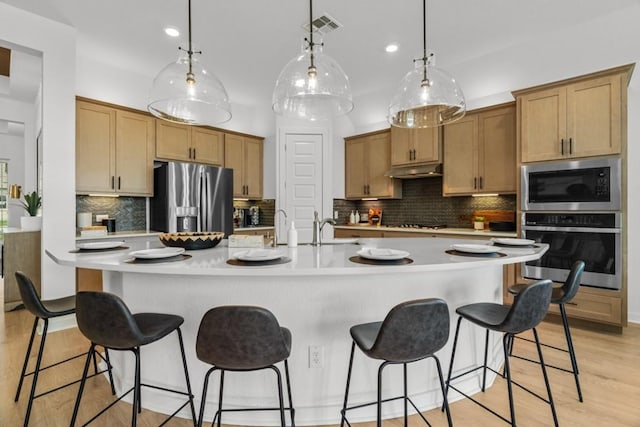 13615 Thomas Wheeler Way, Manor, TX 78653 - kitchen featuring appliances with stainless steel finishes, tasteful backsplash, a breakfast bar area, light countertops, and recessed lighting