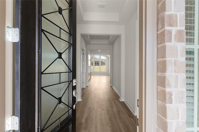 13504 Thomas Wheeler Way, Manor, TX 78653 - corridor featuring a tray ceiling, dark wood-type flooring, and baseboards